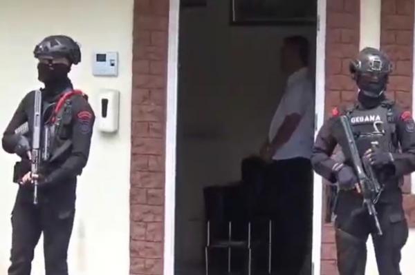 Penyidik KPK dengan pengawalan Brimob membawa koper barang bukti dari kantor dinas di Langkat