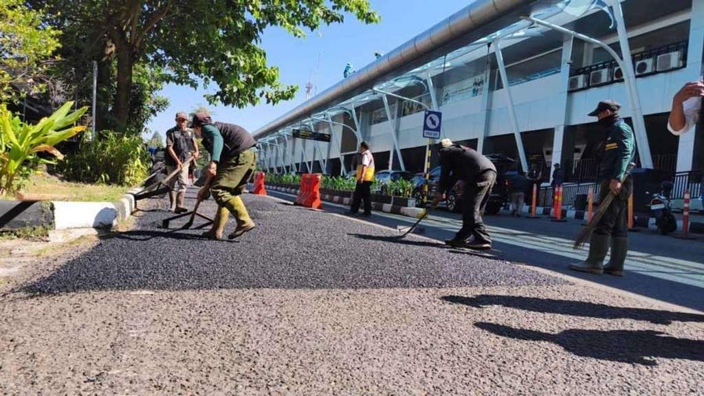 Pekerja mengaspal jalan akses utama menuju Bandara Husein Sastranegara Bandung