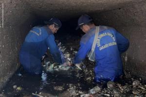 Petugas menyusuri gorong-gorong dan mengeruk sedimen lumpur di Jalan Melawai I Jakarta Selatan